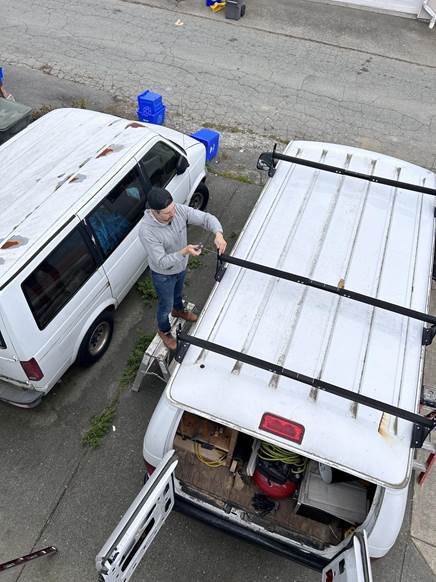 Painter and carpenter putting tools in the van.